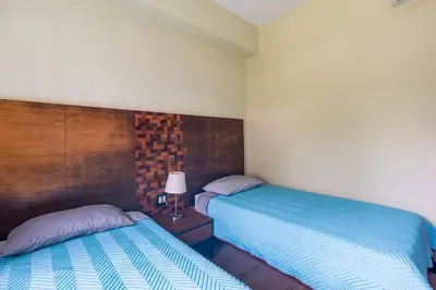 two beds sitting next to each other in a bedroom at Condo Playa Hermosa, Puntarenas in Muñeco