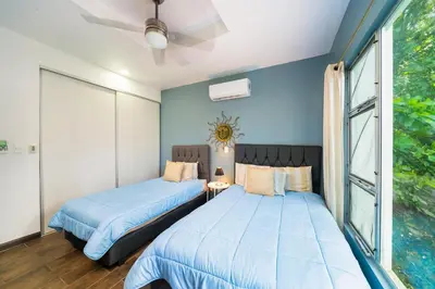 two beds in a room with blue walls at Condo Casa Blanca 7 - NEW 2 BR condo, near to the beach in Potrero