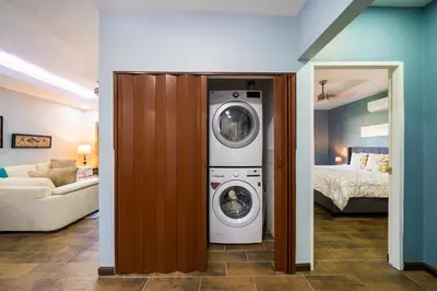 a washer and dryer in a room with a bedroom at Condo Casa Blanca 7 - NEW 2 BR condo, near to the beach in Potrero