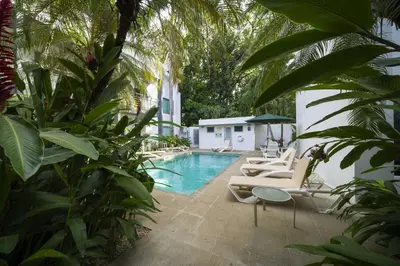 a swimming pool with lounge chairs next to a house at Condo Casa Blanca 7 - NEW 2 BR condo, near to the beach in Potrero