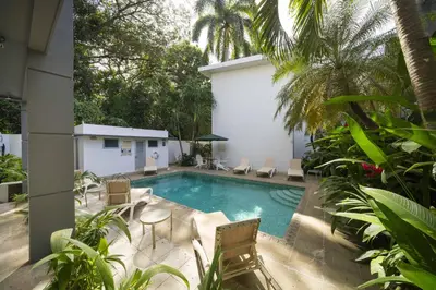 a swimming pool with chairs and a table in a yard at Condo Casa Blanca 7 - NEW 2 BR condo, near to the beach in Potrero