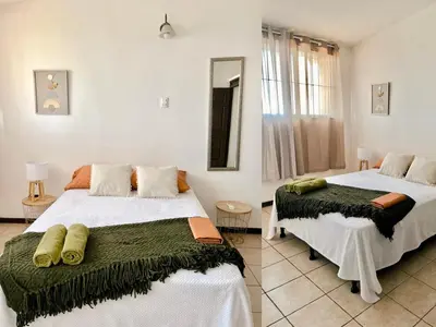 a bedroom with two beds and a mirror at Frente al mar lof in Puntarenas