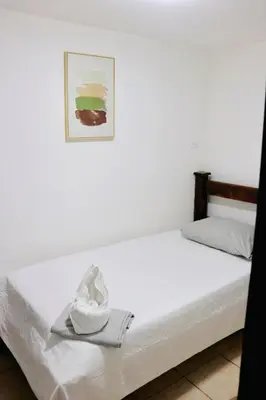 a bed with a hat and a picture on it at Frente al mar lof in Puntarenas