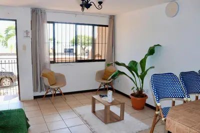 a living room with chairs and a table and a plant at Frente al mar lof in Puntarenas