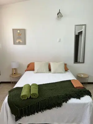 a bedroom with a bed with two green pillows on it at Frente al mar lof in Puntarenas