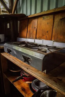a stove top oven sitting on top of a wooden shelf at Flutterby House Hostel in Uvita