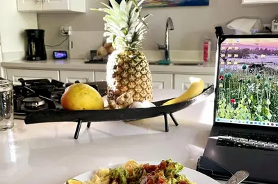 a table with a plate of food and a laptop at An abundance of wildlife at Jungle Glory Home Abajo in Manuel Antonio