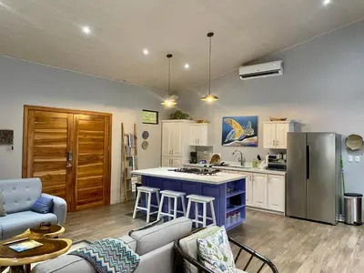 a kitchen with a blue island in a room at An abundance of wildlife at Jungle Glory Home Abajo in Manuel Antonio
