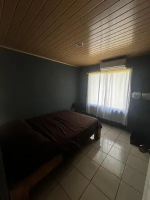 a bedroom with a bed with a wooden ceiling and a window at Casa Ara Macao in Paquera