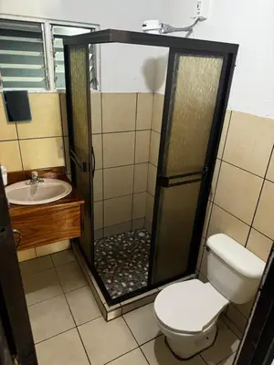 a bathroom with a shower with a toilet and a sink at Casa Ara Macao in Paquera