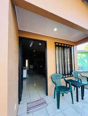 a patio with two chairs and a table on a building at Casa Ara Macao in Paquera