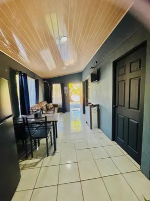 a living room with a door and a table and chairs at Casa Ara Macao in Paquera