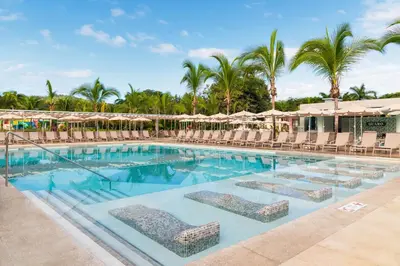 a pool with chairs and umbrellas at a resort at Riu Guanacaste - All Inclusive in Coco