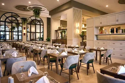 a restaurant with tables and chairs in a room at Riu Guanacaste - All Inclusive in Coco