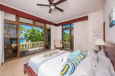 a bedroom with a bed and a view of the ocean at Casa Del Mar - 4 Br House In Flamingo in Playa Flamingo