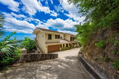 a house on a hill with a driveway at Casa Del Mar - 4 Br House In Flamingo in Playa Flamingo