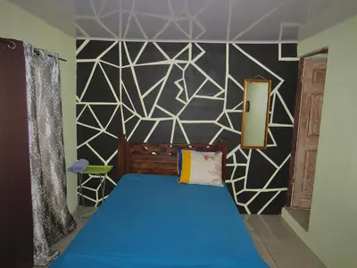 a bedroom with a blue bed and a black and white wall at House la Rose Second Floor in Manuel Antonio