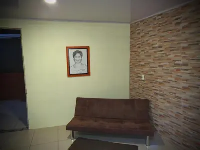 a couch sitting in a room with a brick wall at House la Rose Second Floor in Manuel Antonio