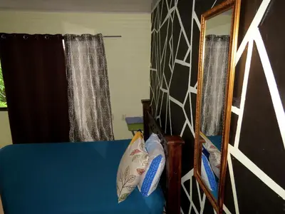 a bedroom with a blue bed and a mirror at House la Rose Second Floor in Manuel Antonio