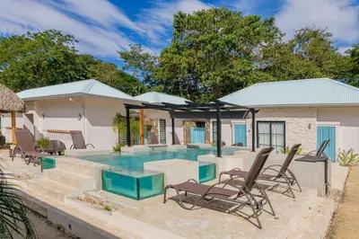 a villa with a swimming pool and chairs at Villas VR Beachwalk Avellanas in Playa Avellana