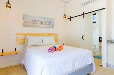a bedroom with a white bed with two life jackets on it at Villas VR Beachwalk Avellanas in Playa Avellana