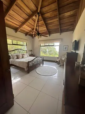 a bedroom with a bed and a wooden ceiling at Casa areno lodge in Bijagua