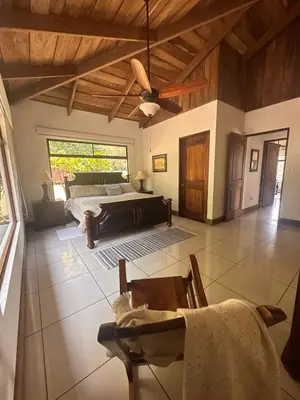 a bedroom with a bed and a ceiling fan at Casa areno lodge in Bijagua