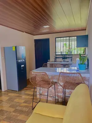 a kitchen with a table and chairs and a refrigerator at Casa Heliconia- La Fortuna in Fortuna