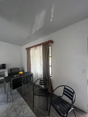 a room with two chairs and a table and a window at Buganvilla No 4 Aire acondicionado in Quepos