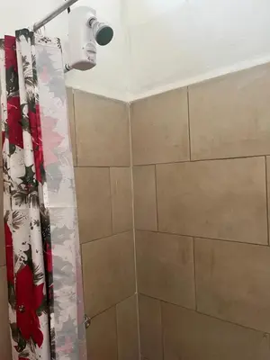 a bathroom with a shower with a shower curtain at Buganvilla No 4 Aire acondicionado in Quepos