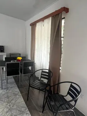 a room with chairs and a table and a window at Buganvilla No 4 Aire acondicionado in Quepos