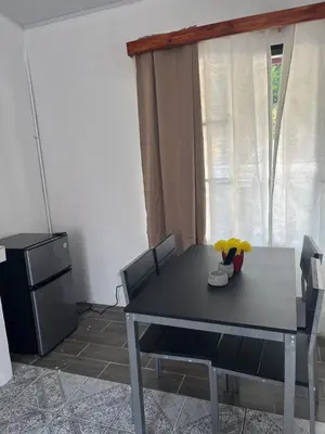 a dining room with a table and a refrigerator at Buganvilla No 4 Aire acondicionado in Quepos