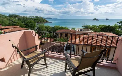 two chairs on a balcony with a view of the ocean at Casa Calle La Ronda At Las Catalinas in Playa Danta