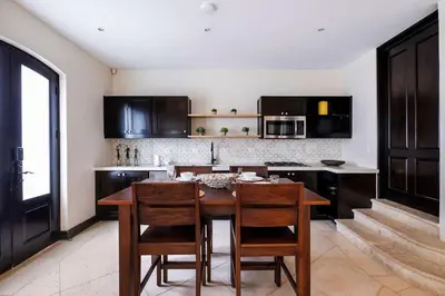 a kitchen with a wooden table and some chairs at Apartment Calle La Ronda At Las Catalinas in Playa Danta