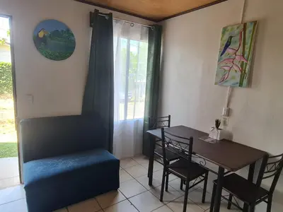 a dining room with a table and chairs and a window at Cabinas Guayabón #4, AC, La Fortuna Volcán Arenal in Fortuna