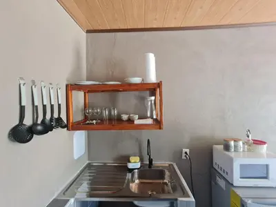 a kitchen with a sink and a stove with utensils at Cabinas Guayabón #4, AC, La Fortuna Volcán Arenal in Fortuna