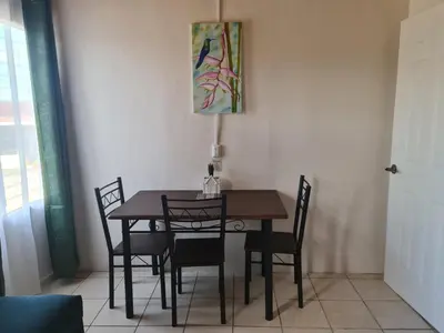 a dining room table and chairs with a painting on the wall at Cabinas Guayabón #4, AC, La Fortuna Volcán Arenal in Fortuna