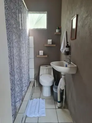 a bathroom with a toilet and a sink at Cabinas Guayabón #4, AC, La Fortuna Volcán Arenal in Fortuna