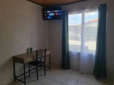 a room with a desk and a window with a monitor at Cabinas Guayabón #4, AC, La Fortuna Volcán Arenal in Fortuna