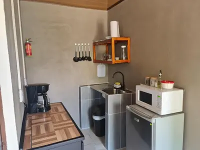 a small kitchen with a sink and a microwave at Cabinas Guayabón #4, AC, La Fortuna Volcán Arenal in Fortuna