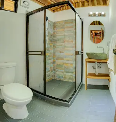 a bathroom with a shower and a toilet and a sink at Sámara Tarantela Houses, Casa Coyol in Sámara