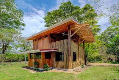 a small wooden building with a roof at Sámara Tarantela Houses, Casa Bambú in Sámara