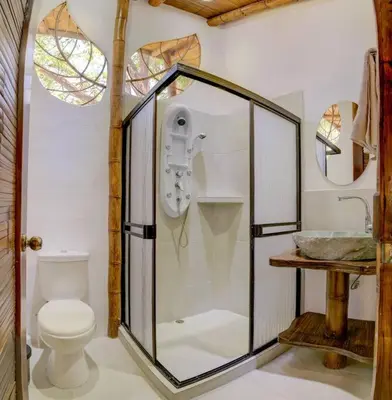 a bathroom with a glass shower and a toilet at Sámara Tarantela Houses, Casa Guadua in Sámara