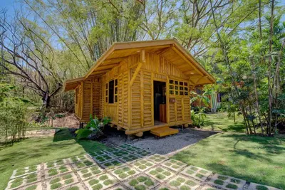 a small yellow building in the middle of a yard at Sámara Tarantela Houses, Casa Sandal in Sámara