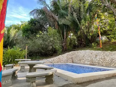 a swimming pool with two benches and a table and sidx sidx sidx at Sámara Tarantela Houses, Casa Sandal in Sámara