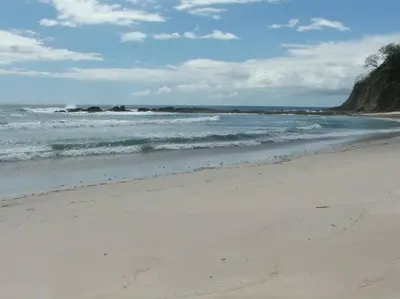 a sandy beach with waves in the ocean at Sámara Tarantela Houses, Casa Sandal in Sámara