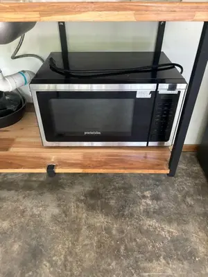 a microwave sitting on a wooden table with a black cord at Casa Mar 1 Manzanillo St Teresa in Boca de Ario