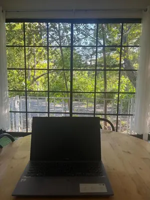 a laptop sitting on a wooden table in front of a window at Casa Mar 1 Manzanillo St Teresa in Boca de Ario