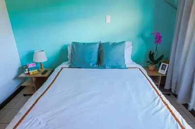 a bed in a room with a blue wall at Posada Nena Santa Ana in Santa Ana