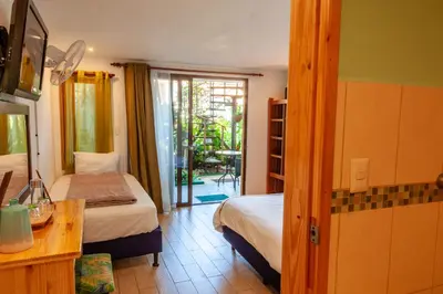 a bedroom with a bed and a table and a door at Posada Nena Santa Ana in Santa Ana